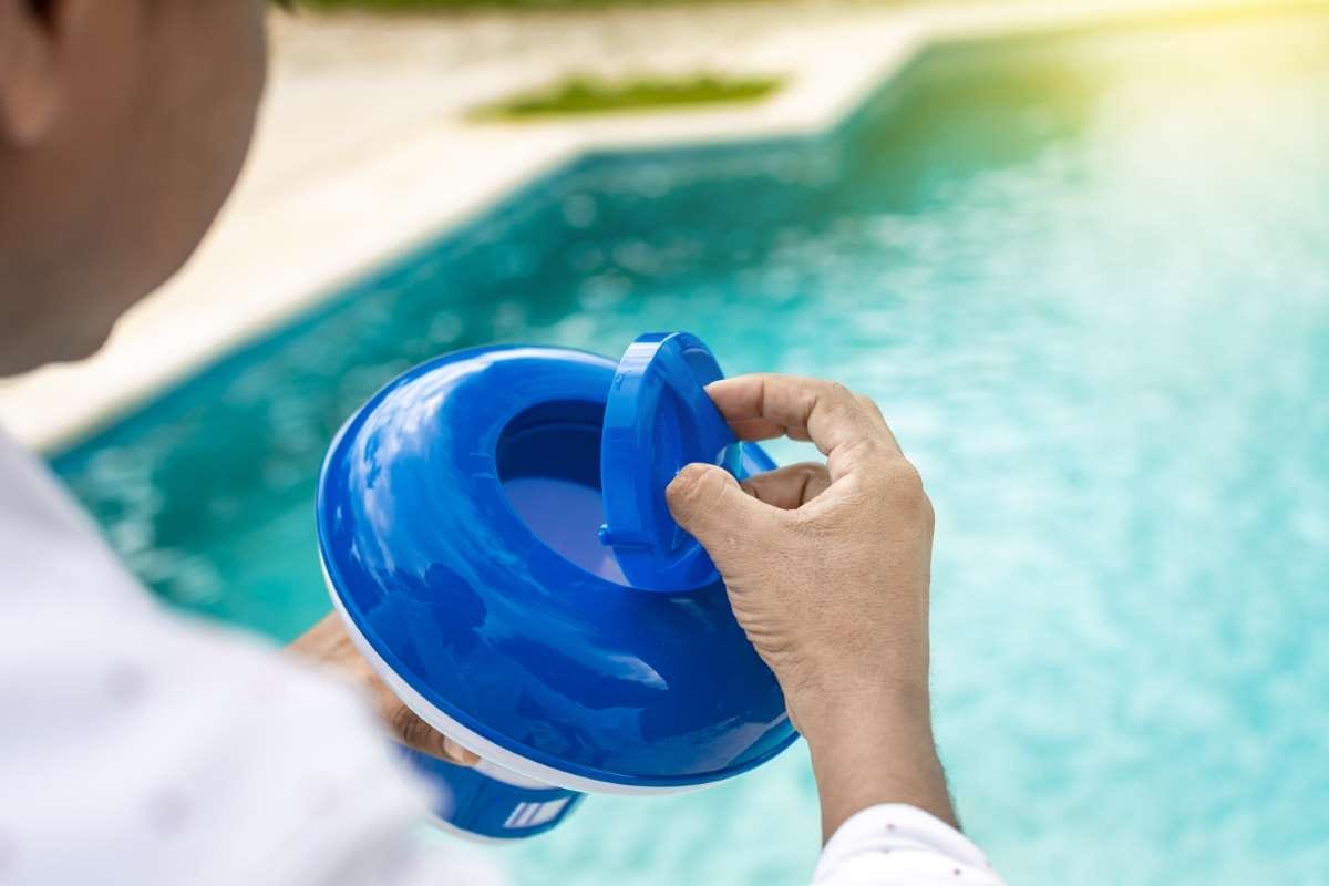 Worker holding a pool chlorine dispenser in hands