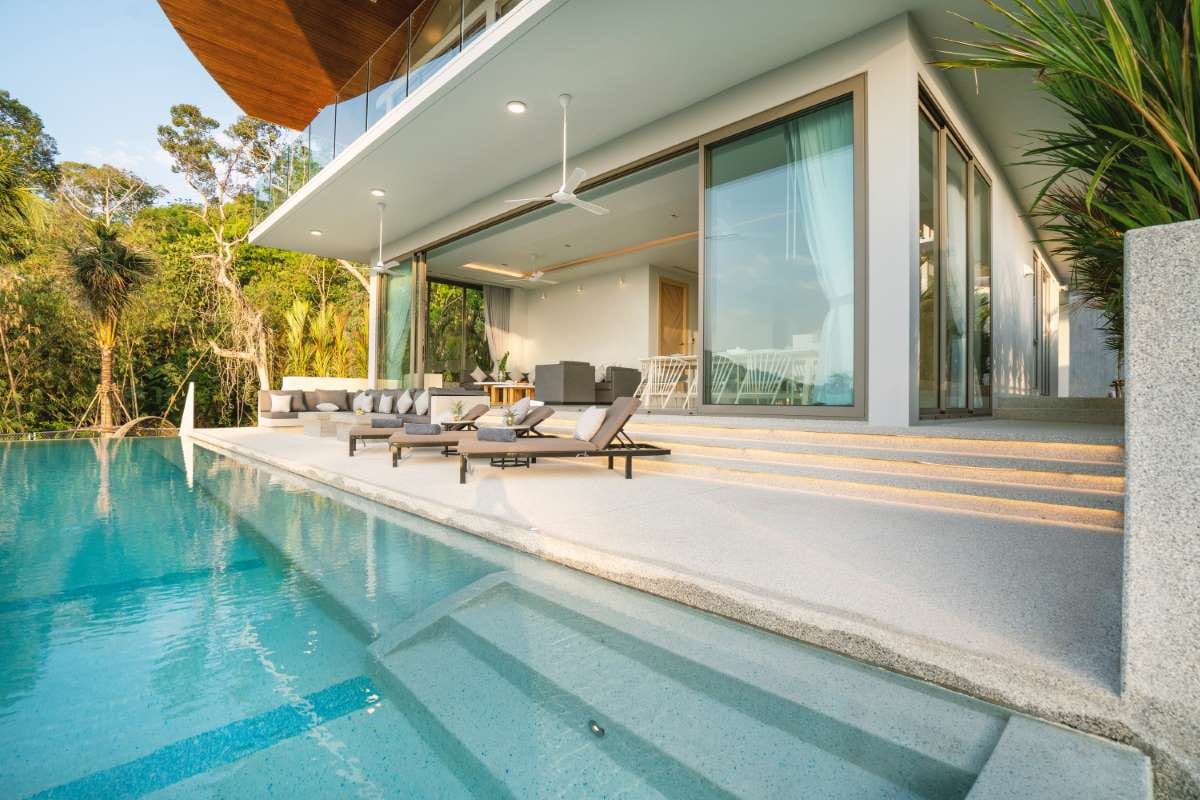 Luxury villa pool terrace with sun beds and modern interior-exterior design