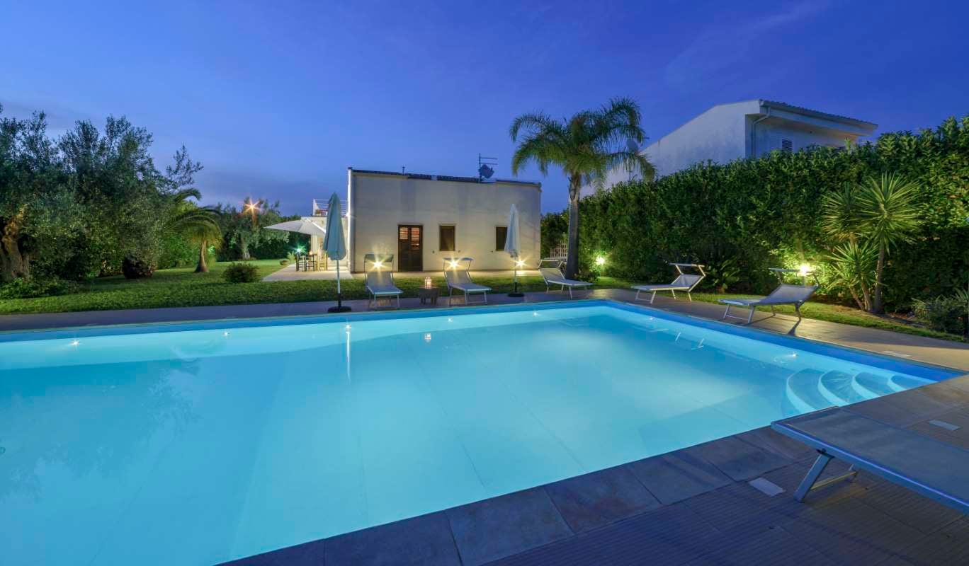 Elegant private house with garden and swimming pool at sunset in rural Sicily