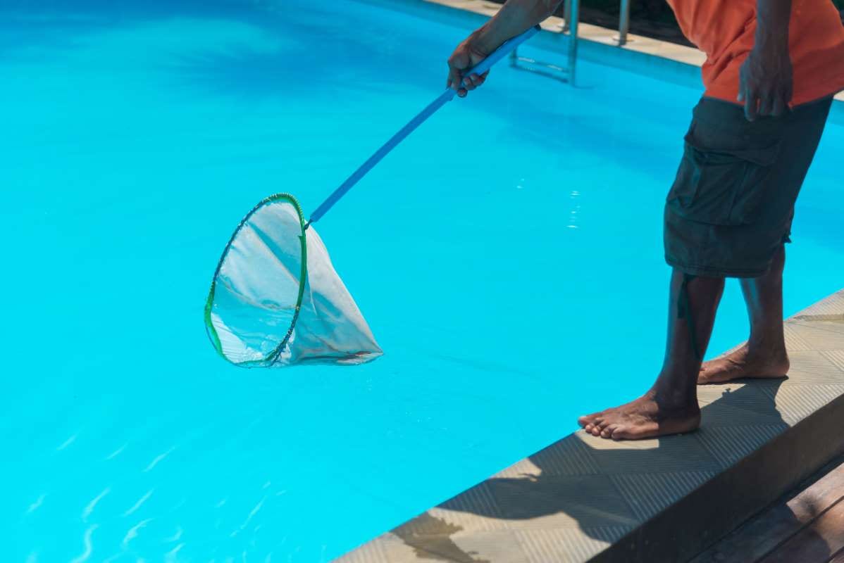 Man standing beside a swimming pool, low section view
