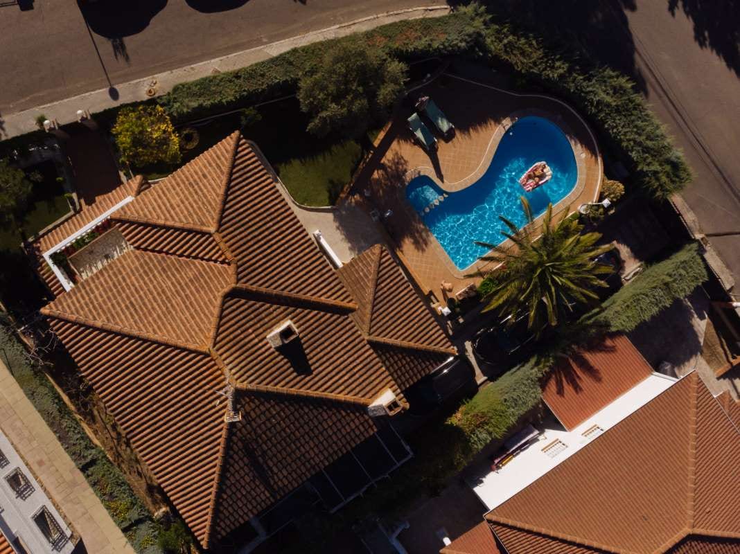 Man floating on a mattress in a villa swimming pool