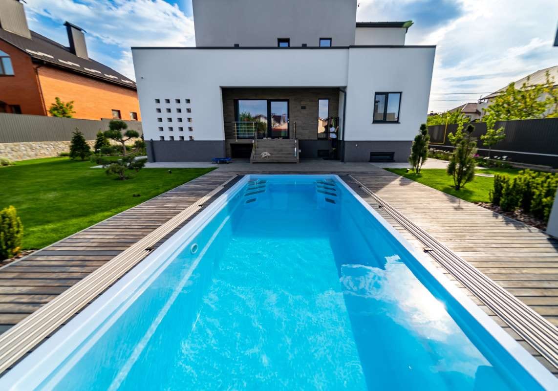 Luxury home garden pool with clear water and lush landscaping