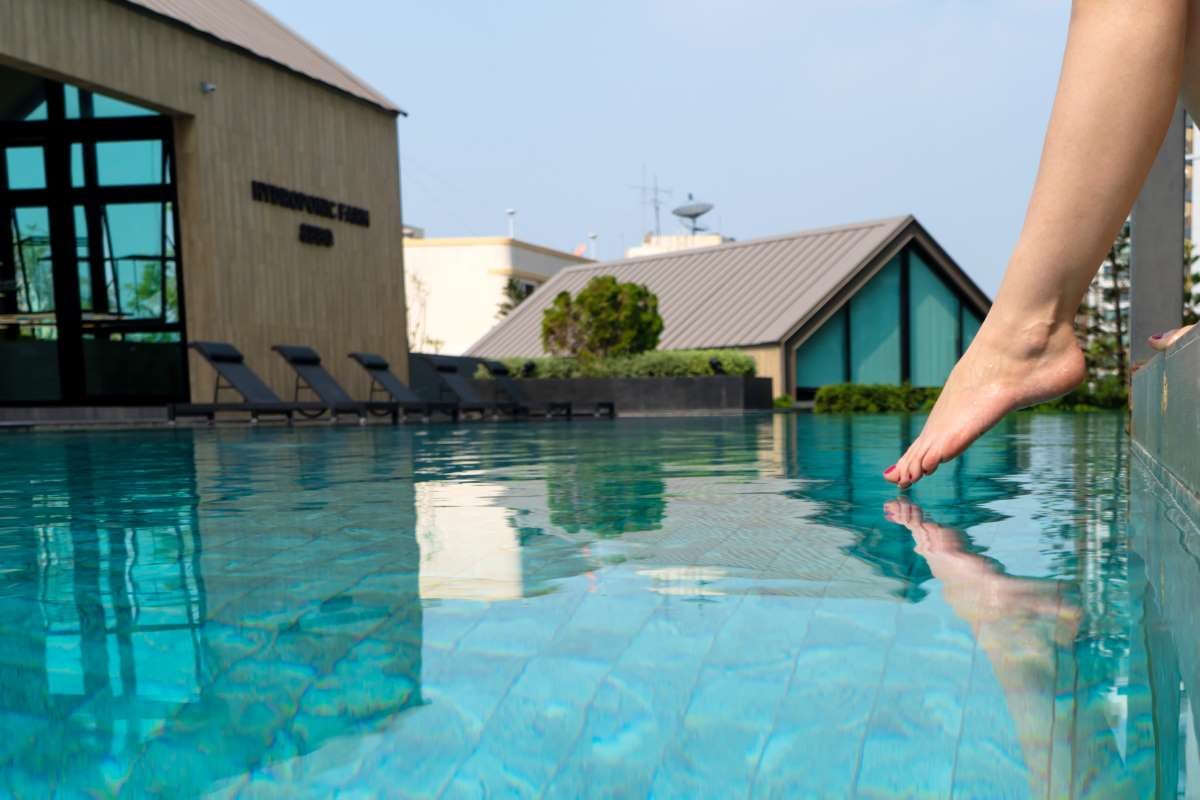 Pool technician checking water temperature during routine service