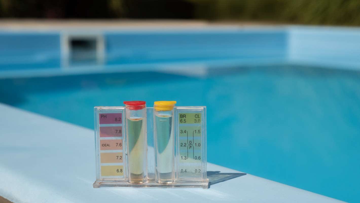 Pool water testing kit with pH and chlorine levels at the pool’s edge