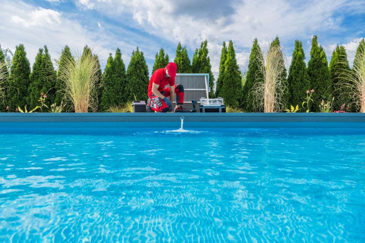 Professional swimming pool technician performing seasonal maintenance