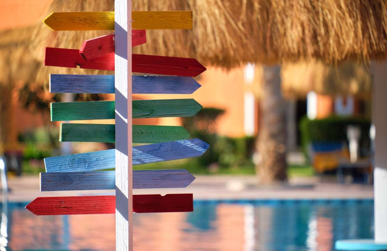 Colorful tropical signboard near an outdoor pool in bright summer sun