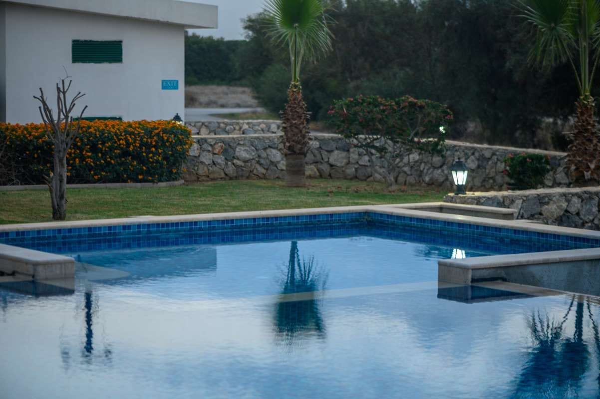 Residential pool beside a house at sunset