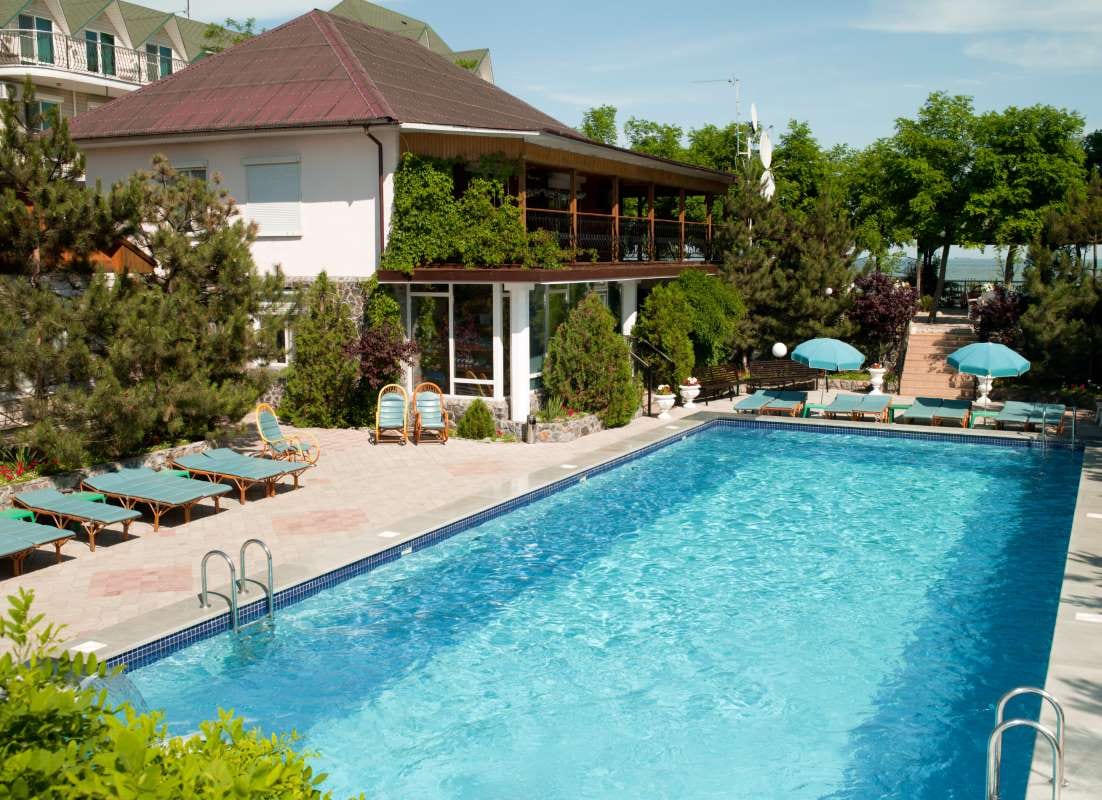 Hotel poolside seating for leisure travelers under a sunny sky