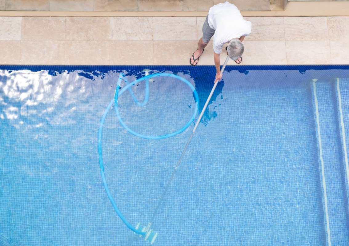 Top view of a man cleaning a swimming pool