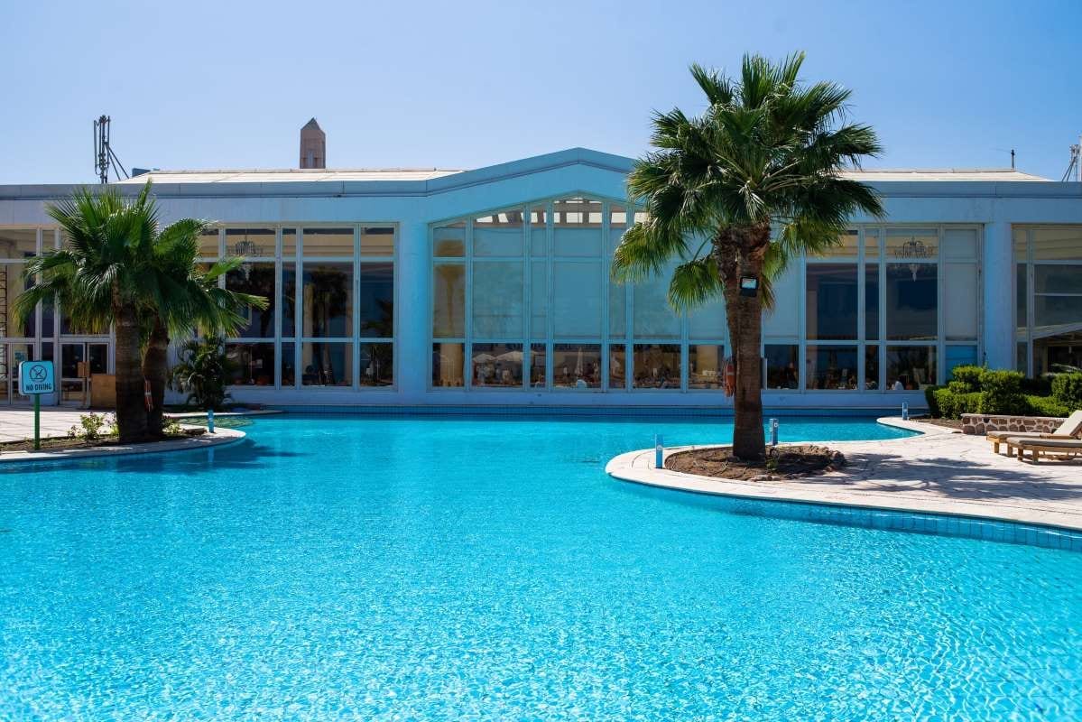 Tropical resort with palm trees and pool under clear skies